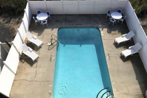an overhead view of a swimming pool with chairs and tables at Easy Breezy in Carolina Beach