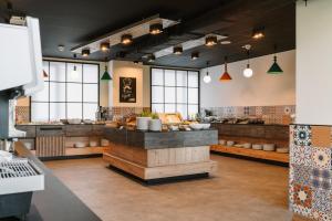 a kitchen with a counter in a room with windows at Easy One Premium Art Hostel in Kraków