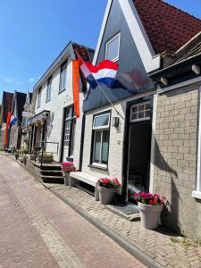 Una casa con una bandera a un lado. en Het Heertje, en Den Hoorn