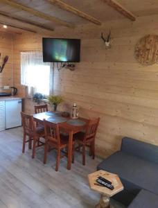 a dining room with a table and a tv on a wall at Rajskie wzgórze w Karkonoszach in Łomnica