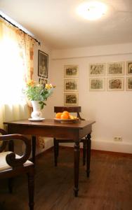 einen Tisch mit einer Vase aus Blumen und Orangen darauf in der Unterkunft Gästehaus Cheval Blanc in Lorch am Rhein