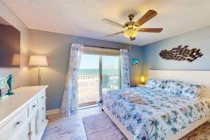 a bedroom with a bed and a ceiling fan at Saltwater Kure in Kure Beach