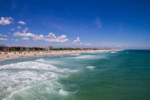 a group of people on a beach with the ocean at Paradise Found in Carolina Beach