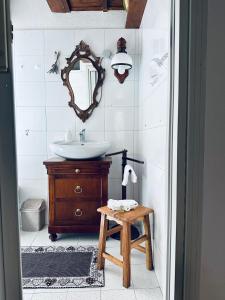 y baño con lavabo, espejo y mesa. en Casa Voje, en Serra Rocco