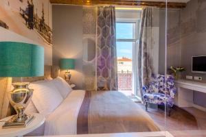 um quarto com uma cama, uma janela e uma cadeira em Procurator 7 Luxury Rooms em Split