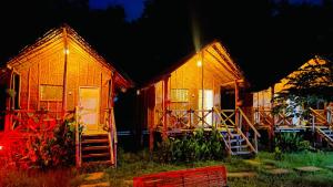 Un par de casas con sus puertas abiertas por la noche en HAPPY PLACE HAMPI, en Hampi