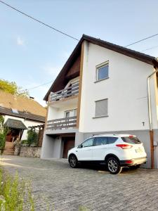 une voiture blanche garée devant une maison dans l'établissement Gästezimmer Bernkastel - Gästehaus Barbara, à Bernkastel-Kues