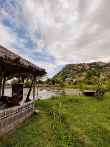 una cabaña en un campo junto a un río en HAPPY PLACE HAMPI en Hampi