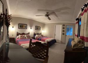 um quarto com 2 camas e uma ventoinha de tecto em Casa Tecolote em Guanajuato