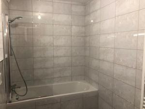 a white bathroom with a tub and a shower at Apartment A304 La Perle de Savoie in Châtel +28 photos