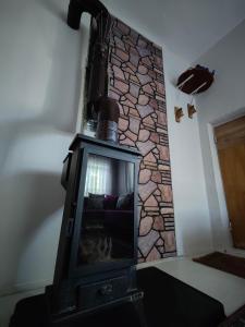 Una chimenea en una habitación con una pared de piedra. en Cosy Cottage with fireplace and garden - Close to City centre and Skii Resort, en Melikgazi