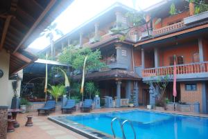 a swimming pool in front of a building at Hotel Sorga Cottages in Kuta