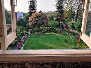 uma vista para um jardim a partir de uma janela em Private room with a view em Dehradun