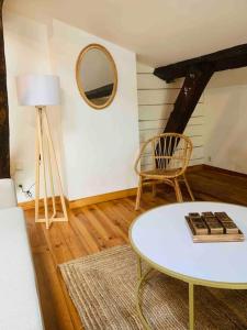 a living room with a table and a mirror at Spacieux appartement en plein coeur de Castres in Castres