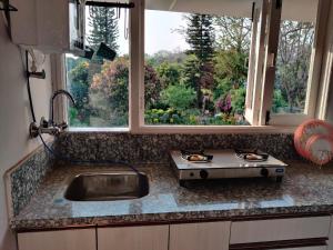 um balcão de cozinha com uma pia e uma janela em Private room with a view em Dehradun