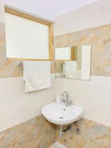 W łazience znajduje się umywalka i lustro. w obiekcie Private room with a view w mieście Dehradun