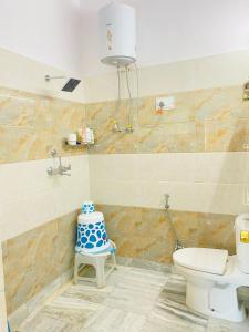 łazienka z toaletą i krzesłem z ciastem w obiekcie Private room with a view w mieście Dehradun