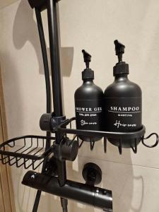 two black bottles are hanging on a rack at Studio Saint-Laurent-Du-Var 50m de la mer in Saint-Laurent-du-Var