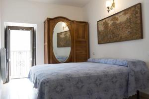 um quarto com uma cama grande e um espelho em Casa Mastro Pietro em Fontecchio