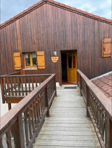 un edificio de madera con una pasarela de madera que conduce a una puerta en Chalet duplex avec terrasse entièrement équipé60m2 en Gérardmer