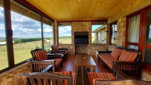 a screened in porch with couches and a fireplace at Berryfields in Dullstroom