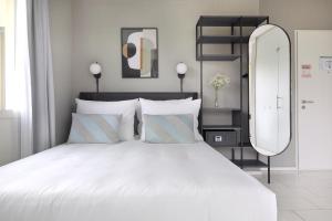 a bedroom with a large white bed with a large mirror at numa I Turi Apartments in Zürich