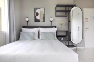 a bedroom with a large white bed with a large mirror at numa I Turi Apartments in Zurich