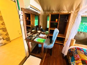 Wag Hill Lodge & Spa في موانزا: غرفة مع مكتب وسرير في منزل صغير