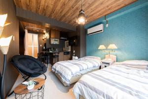 um quarto de hotel com duas camas e uma cadeira em Few Days Condominium 205 em Jozankei
