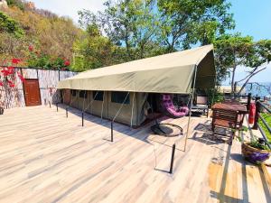 una tenda su una terrazza con tavolo e sedie. di Wag Hill Lodge & Spa a Mwanza