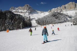 un grupo de personas esquiando por una pista cubierta de nieve en Chambre LA LONGERE, en Treffort