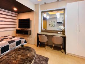 a bedroom with a bed and a desk with a television at * *R Metropolitan Mirage in Iloilo City