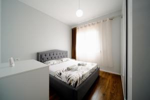 a small bedroom with a bed and a window at Apartamente Tirana in Tirana