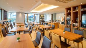 a restaurant with wooden tables and chairs at Meitetsu Inn Nagoya Kanayama in Nagoya