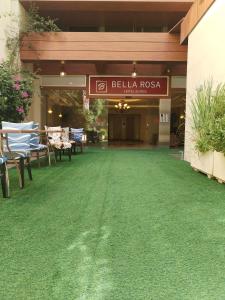 a building with a green lawn in front of a restaurant at Bella Rosa Hotel in Beirut