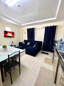 a living room with a blue couch and a table at Exquisite Modern suite 1bedroom in Busia