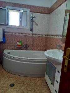 La salle de bains est pourvue d'une baignoire et d'un lavabo. dans l'établissement GuestHouseMantho, à Gjirokastër