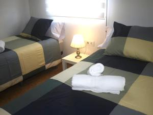 a hotel room with two beds with towels on them at Jardines del Ebro, 8 Pax, ideal grupos y centrico in Logroño