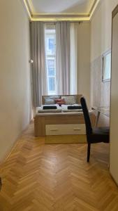 una camera con un letto e una sedia e una finestra di Best of Guest house by Small Home Budapest a Budapest