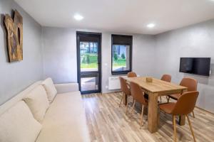 a living room with a table and a couch at Boro Green Holiday Village in Borovets