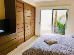a bedroom with a bed with a television and a large window at ☆ Location & Comfort ☆ Jacuzzi ☆ Luxury Condo in Tulum +12 photos