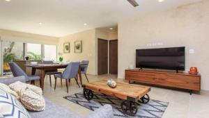 a living room with a large television and a table at ☆ Location & Comfort ☆ Jacuzzi ☆ Luxury Condo in Tulum