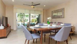 a dining room with a table and chairs and a television at ☆ Location & Comfort ☆ Jacuzzi ☆ Luxury Condo in Tulum
