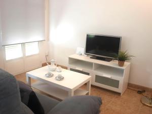 a living room with a tv and a white coffee table at Jardines del Ebro, 8 Pax, ideal grupos y centrico in Logroño