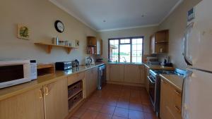 a kitchen with wooden cabinets and a white refrigerator at Berryfields in Dullstroom