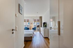 Una habitación con un dormitorio con una cama y un escritorio. en Terralpin Apartments - 27qm, en Bruckmühl