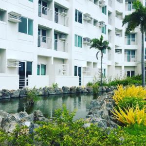 an apartment building with a pond in front of it at condotel anuva in Manila