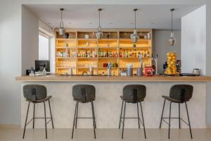 un bar avec trois tabourets de bar dans une pièce dans l'établissement Areti Hotel, à Agia Galini