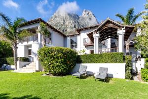 a house with a mountain in the background at The Cape Bali Luxury Villa with Ocean Views in Camps Bay in Cape Town