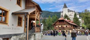 a crowd of people walking down a street next to buildings at Burglodge Fischerkeusche in Mauterndorf